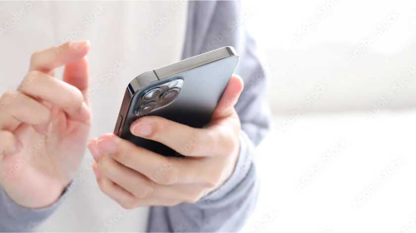 予約確認のため、スマートフォンを操作する。